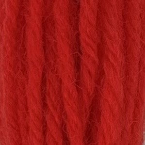 Close-up of hot neon‑orange tapestry wool thread with a soft, fuzzy texture and tightly twisted strands.