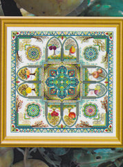 Framed cross stitch of a colorful medieval fruit garden mandala with trees, fruit, birds, and arches arranged around a patterned central medallion.