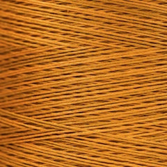 Close-up of golden‑yellow overdyed embroidery floss wound tightly, showing warm tonal variation across the strands.