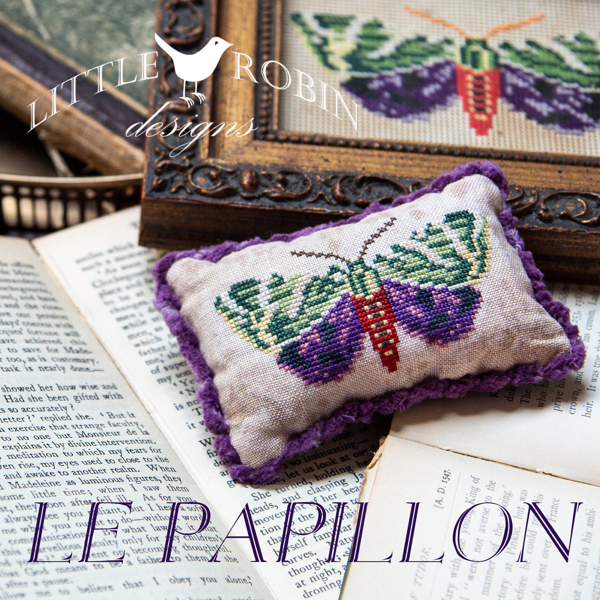 A cross stitch pillow of  butterfly with rich purple and green wings with purple fringe piping on the edges.