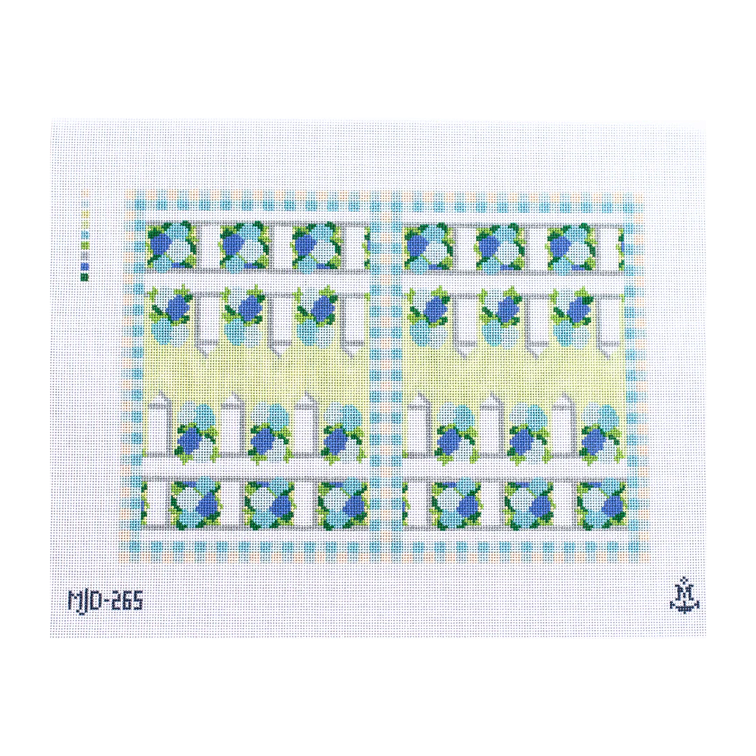 Needlepoint canvas for a backgammon board featuring a light green and blue geometric and floral border design with repeating gate‑like motifs.