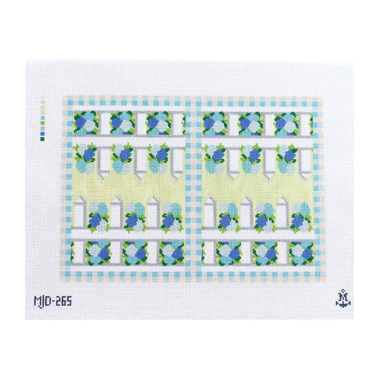 Needlepoint canvas for a backgammon board featuring a light green and blue geometric and floral border design with repeating gate‑like motifs.