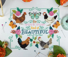 A cross stitch of colorful chickens, blooming flowers, fluttering butterflies, and the phrase “Be Your Own Kind of Beautiful” in the center.