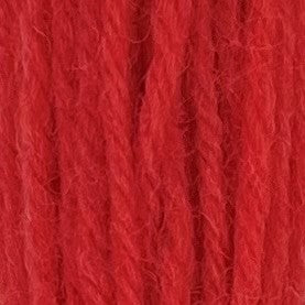 Close-up of sherbert red crewel wool thread with a soft, fuzzy texture and tightly twisted strands.
