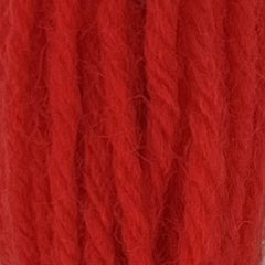 Close-up of hot neon‑orange tapestry wool thread with a soft, fuzzy texture and tightly twisted strands.
