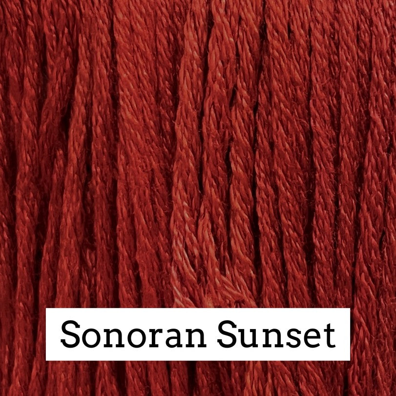 Close-up of deep red silk embroidery floss with subtle darker and lighter variegation, labeled “Sonoran Sunset.”