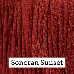Close-up of deep red silk embroidery floss with subtle darker and lighter variegation, labeled “Sonoran Sunset.”
