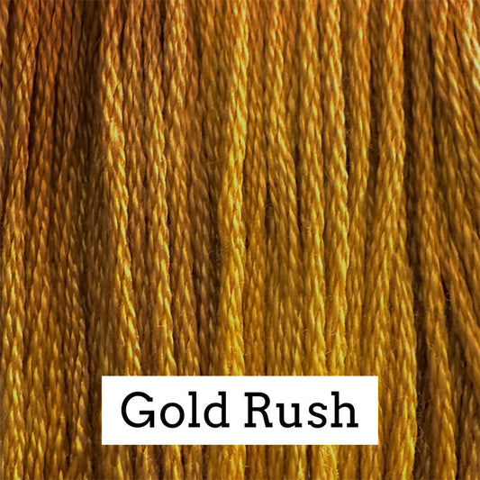 Close-up of golden‑yellow cotton embroidery floss with subtle warm tonal variation, labeled “Gold Rush.”