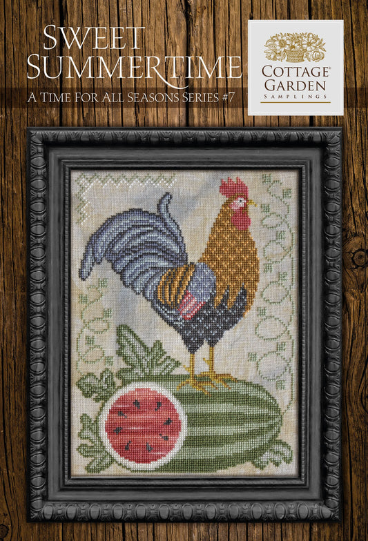 Framed cross-stitch sampler featuring a rooster standing on a large watermelon slice, surrounded by green leaves and vines on a neutral background.
