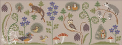 A flat cross stitch scene featuring woodland animals, birds, and mushrooms arranged among ferns and blue flowers in a horizontal layout.
