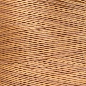 Close-up of tan overdyed embroidery floss wound tightly, showing soft tonal variation across the strands.