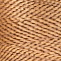 Close-up of tan overdyed embroidery floss wound tightly, showing soft tonal variation across the strands.