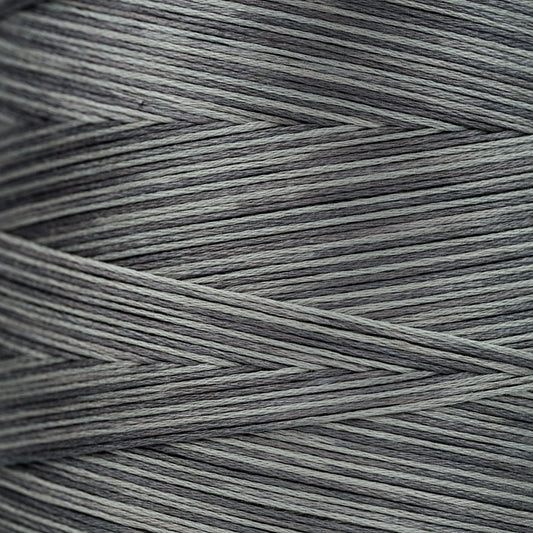 Close-up of gray overdyed embroidery floss wound tightly, showing subtle light and dark tonal variations in the strands.